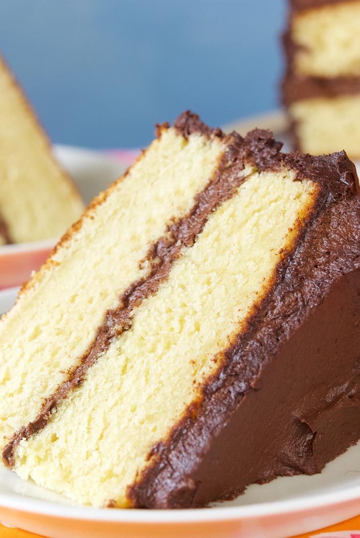 a slice of cake on a plate with other slices in the background and one piece missing