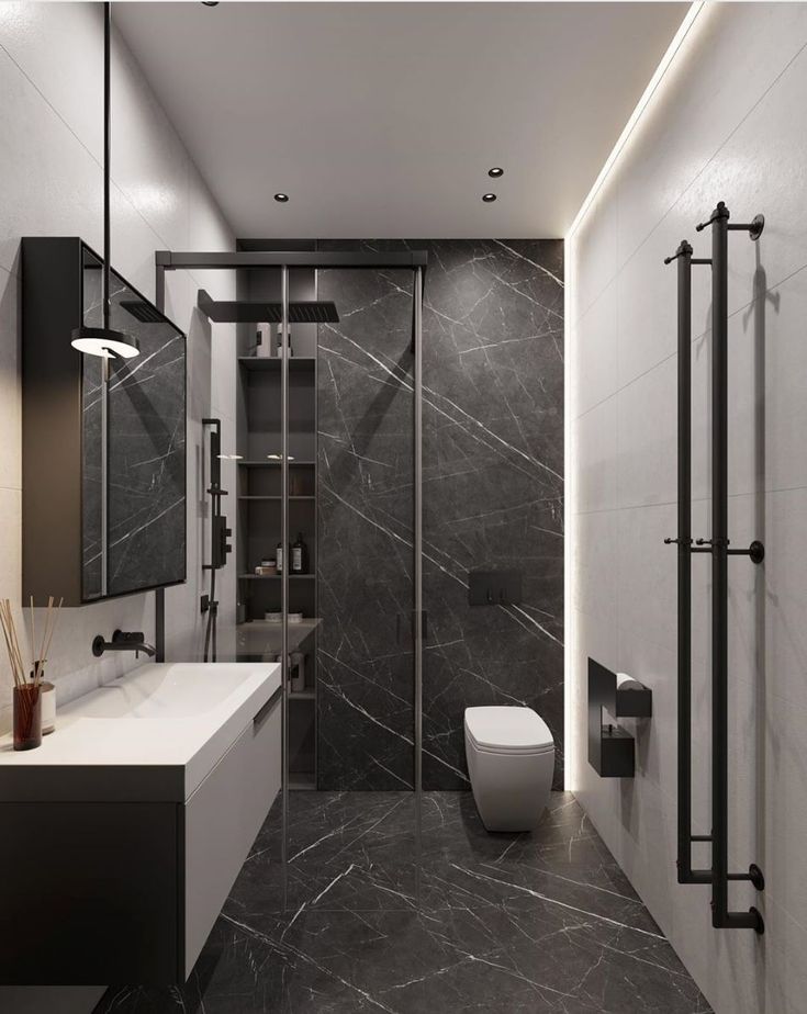 a modern bathroom with black and white marble tiles on the walls, along with a walk in shower