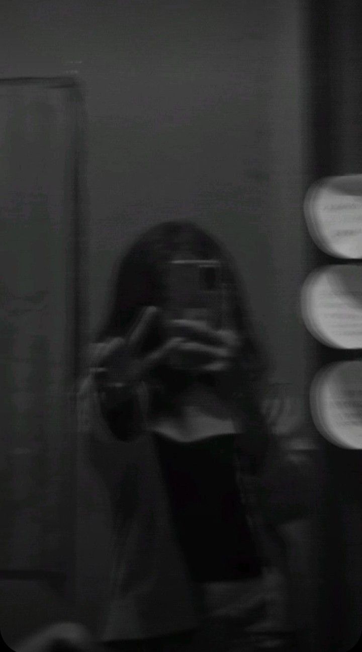 a blurry photo of a woman taking a selfie in front of a mirror