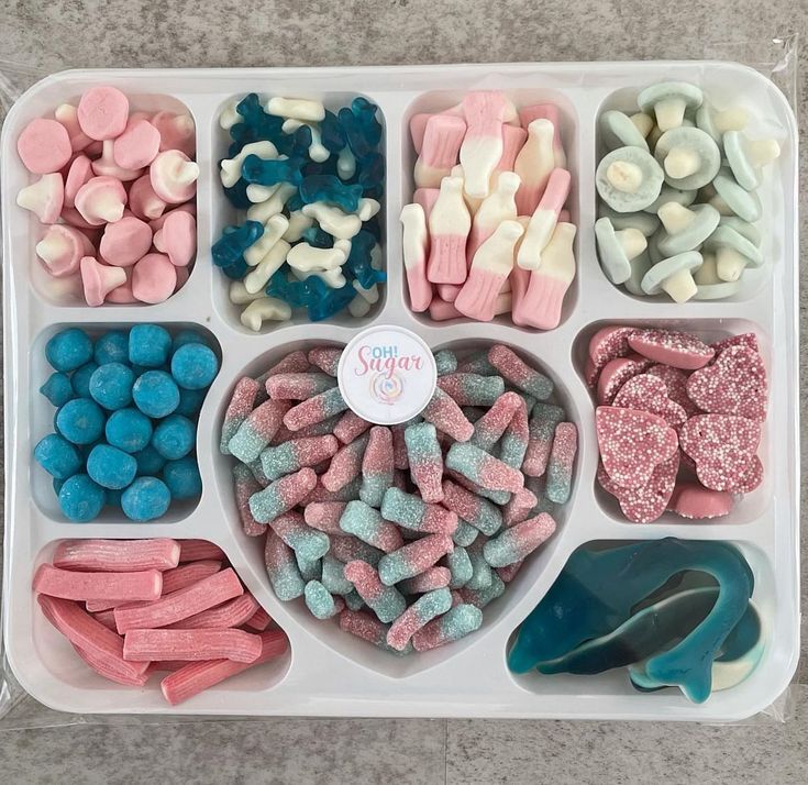 a tray filled with lots of different types of candies and marshmallows