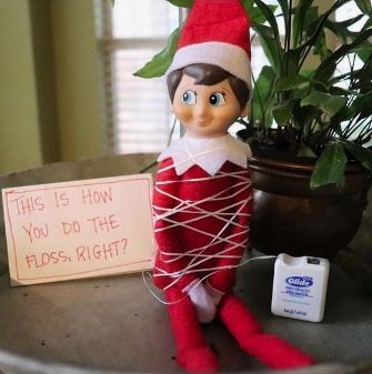 an elf is holding a sign that says, this is how you do the floss right?