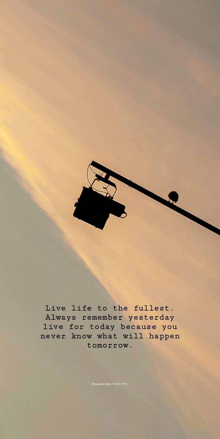 a street light with a sky in the background and a quote on it that says, live life to the fullest