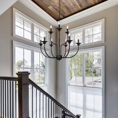 a chandelier hanging from the ceiling in a room with windows and railings