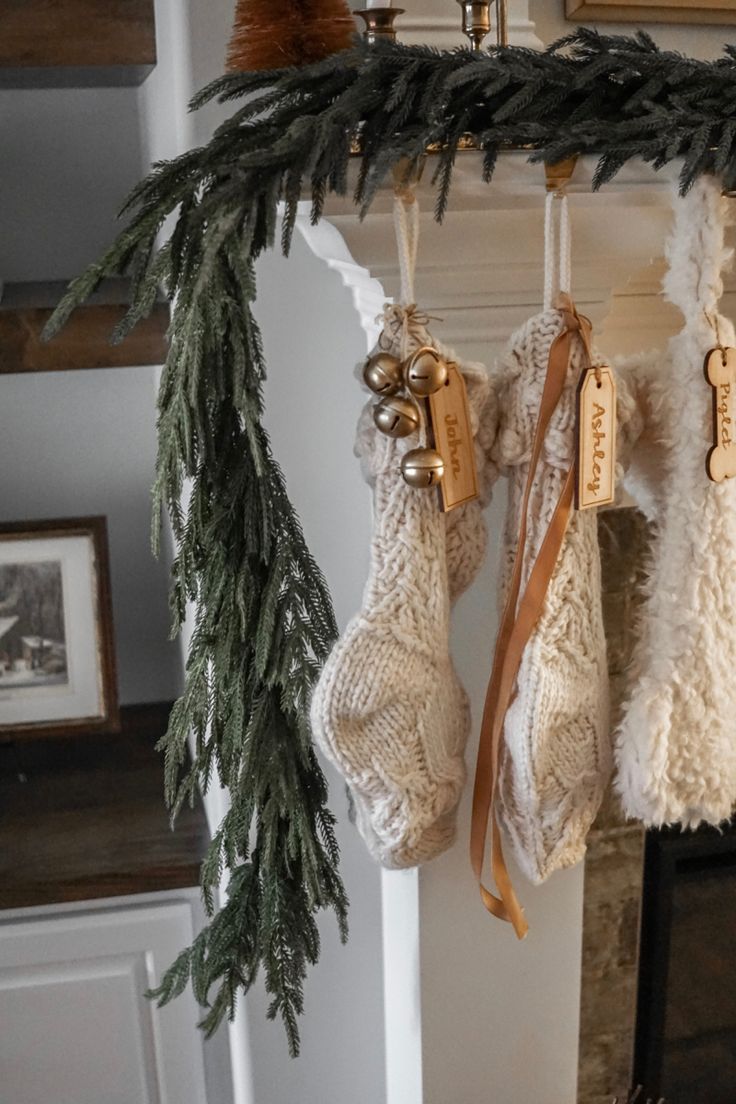 stockings hanging from a mantle with christmas decorations