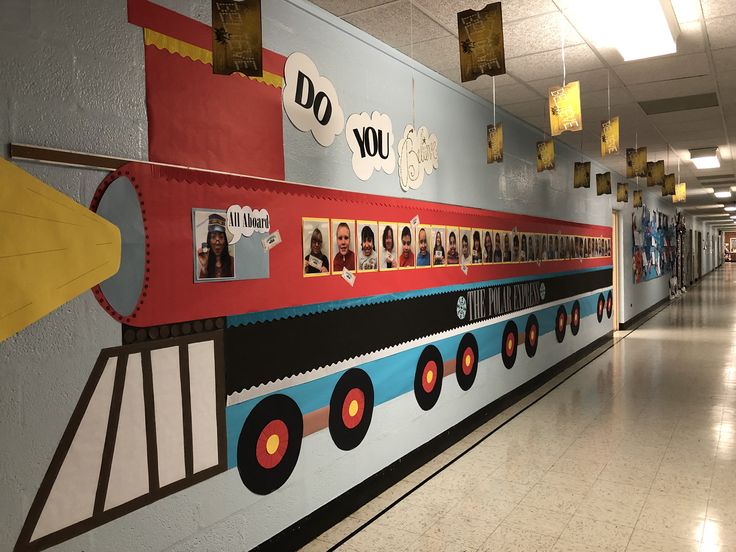 a long hallway with many pictures on the wall and decorations hanging from the ceiling above it