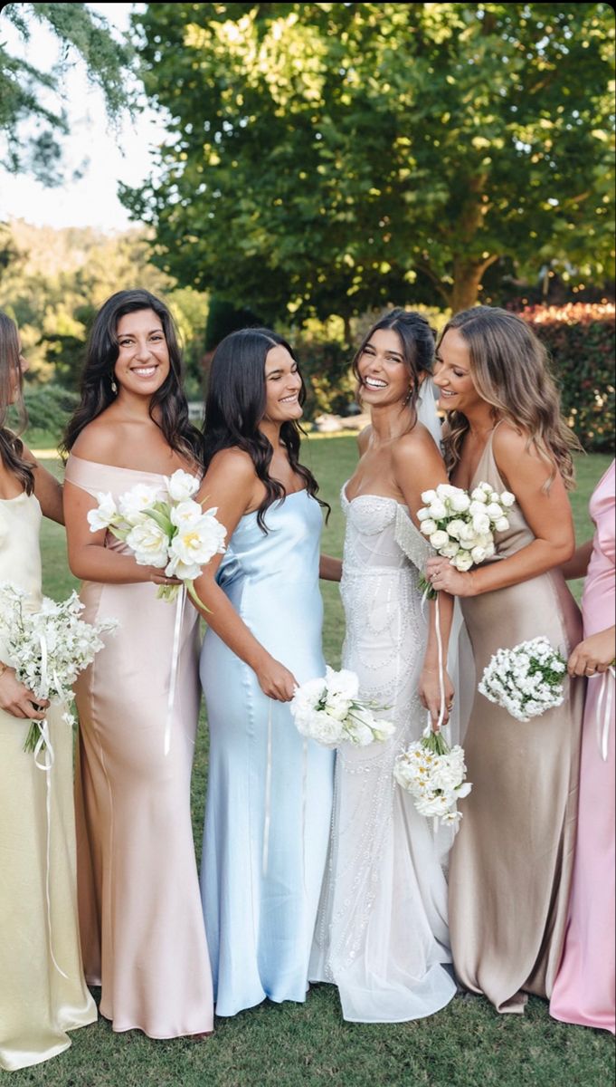 the bridesmaids are all wearing different colored dresses