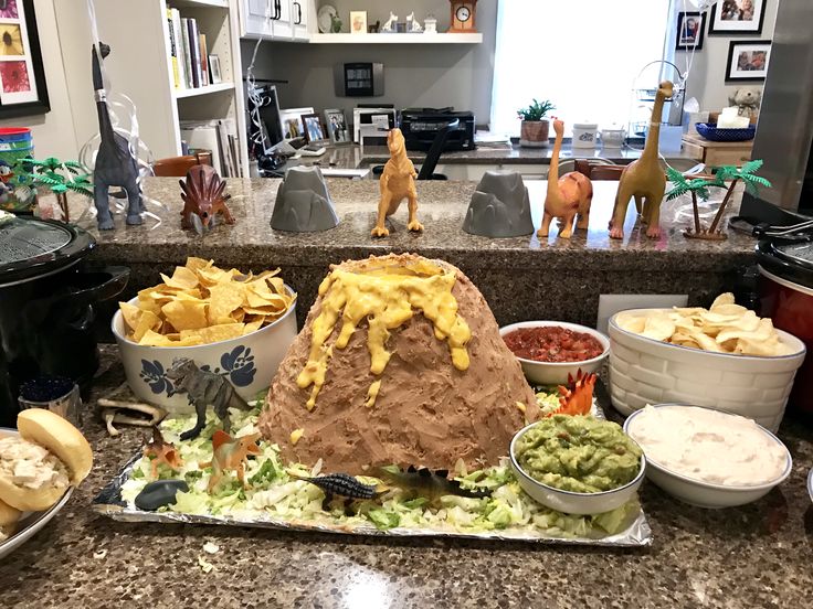 a table topped with lots of food and bowls filled with different types of dips