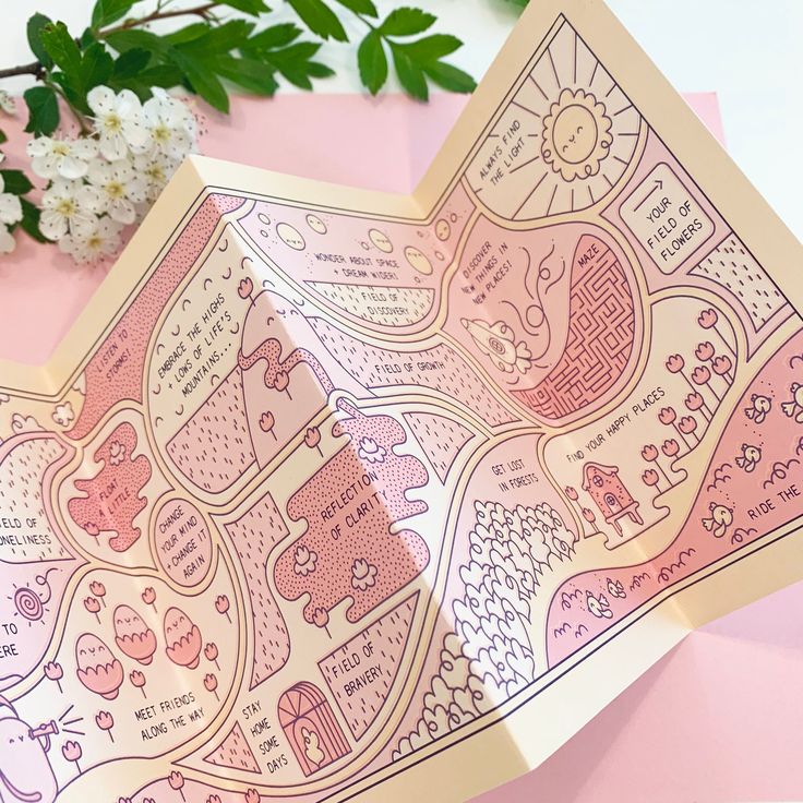 the inside of a pink and white paper with an animal map on it next to some flowers