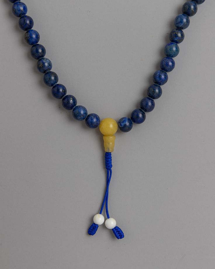 3A Quality Lapis Mala About our Mala Beads Originating in India, the 3A Quality Lapis Mala is a testament to both spiritual significance and expert craftsmanship. The 6mm lapis lazuli beads used in each carefully made mala are prized for their deep blue hue and special qualities. Enhanced with conch and yellow jade dividers, the mala is a symbol of spiritual awakening and prosperity in addition to elegance.The 3A Quality Lapis Mala is a tactile and visual journey towards inner serenity and self- Blue Hand Knotted Round Bead Necklaces, Blue Hand-knotted Round Bead Necklaces, Blue Hand-knotted Necklaces, Blue Round Beads Mala For Meditation, Spiritual Polished Lapis Lazuli Beads, Adjustable Lapis Lazuli Beaded Necklace With 8mm Beads, Blue Spiritual Mala With 8mm Beads, Blue Mala With 8mm Beads For Meditation, Blue 8mm Beads Spiritual Mala