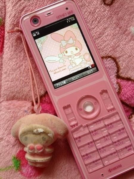 a pink cell phone sitting next to a stuffed animal