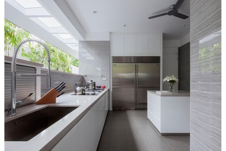 a modern kitchen with stainless steel appliances and white cabinets