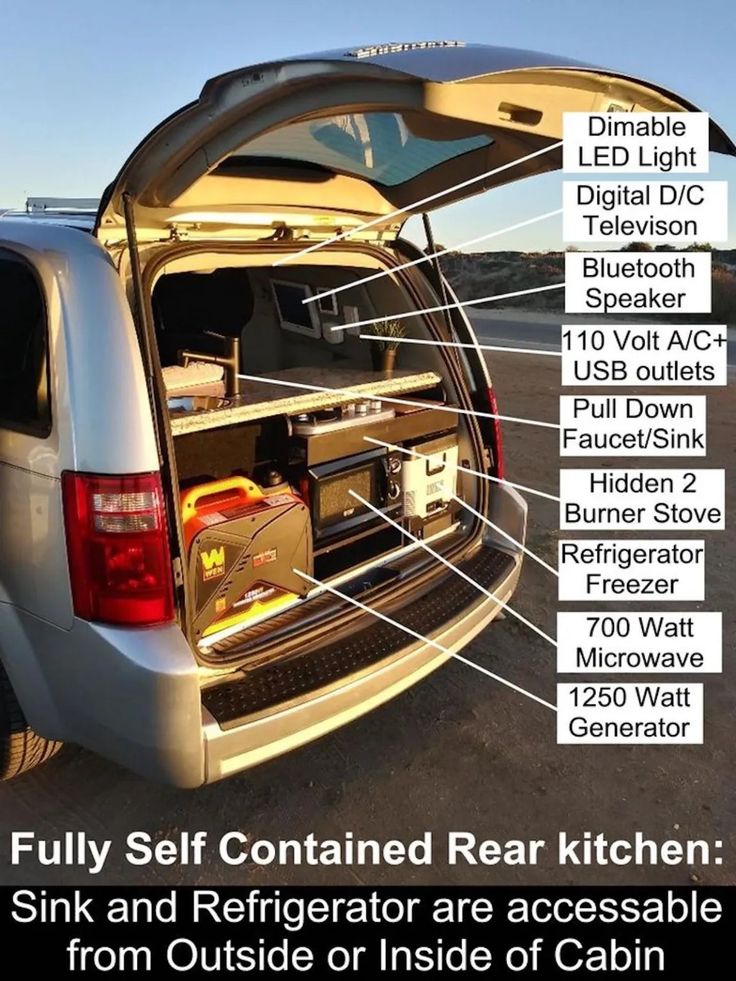 the back end of a silver van with its cargo compartment open and labeled in white