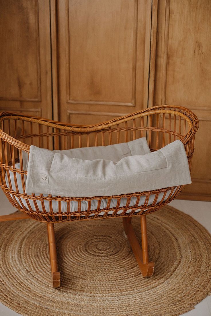 a wicker cradle with a white blanket on it