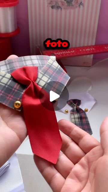 someone is holding a red ribbon in their hand and it looks like they are making something out of fabric