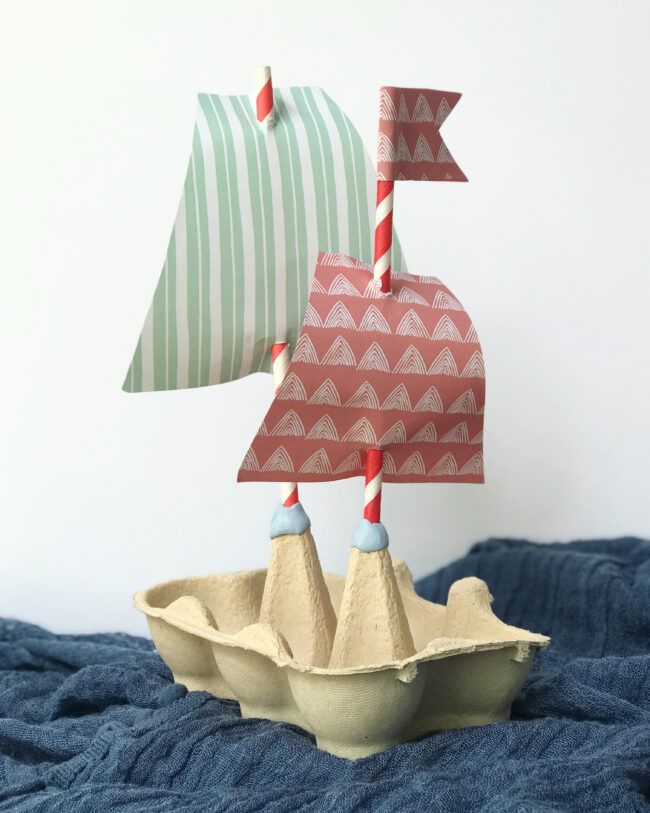 a paper boat sailing on top of an egg shell