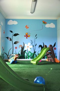 a child's playroom with green carpet, slide and flowers painted on the wall