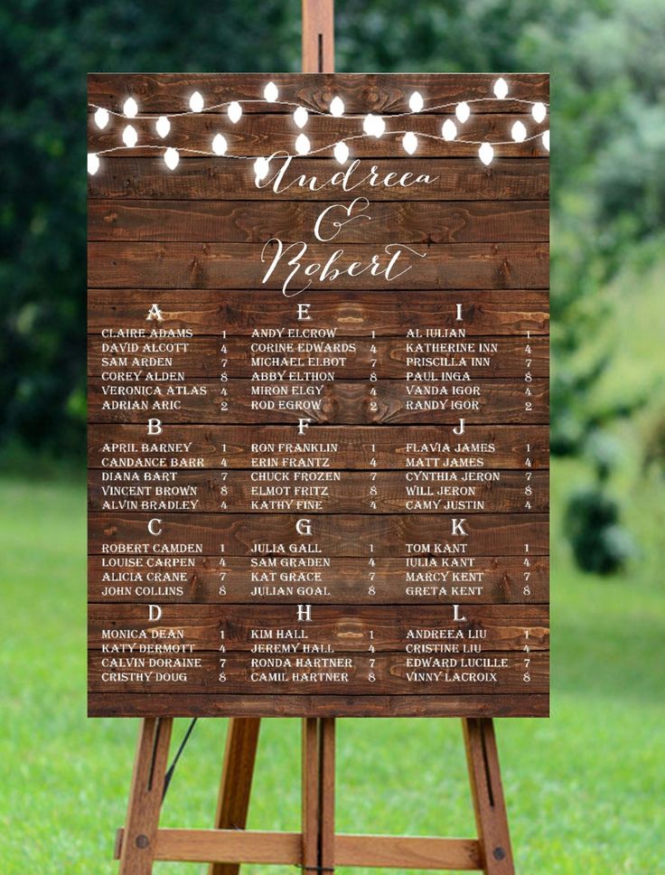 a wooden sign with lights on it that says the names of each wedding ceremony guests