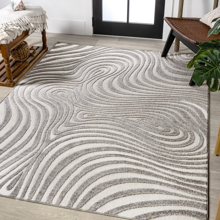 a white and gray rug with wavy lines on the floor in front of a door