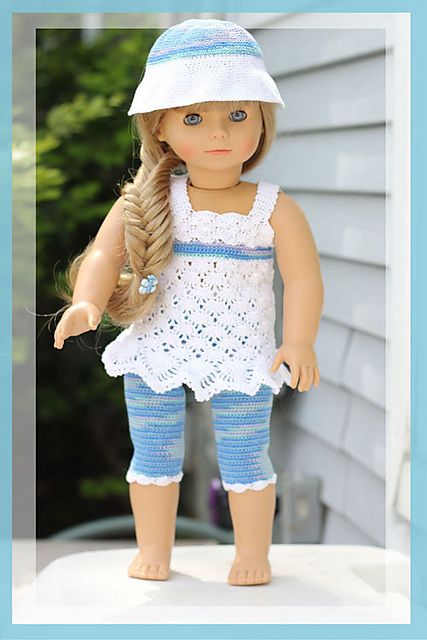 the doll is wearing a white top and blue pants with crochet on it