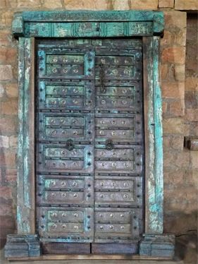 an old wooden door in front of a stone wall