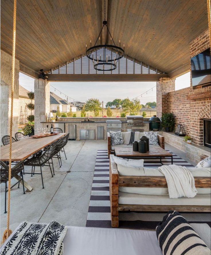 an outdoor covered patio with tables, chairs and couches on the side walk way