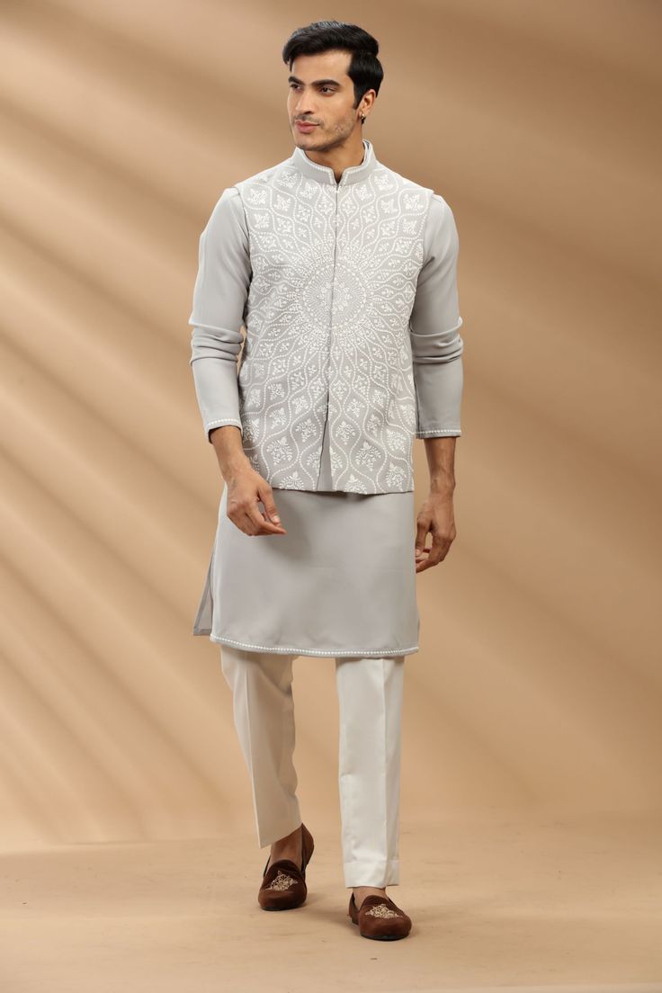 Top Details Color- Grey, Fabric - Soft Suiting Fabric With Embroidered Bottom Details Color- Off White, Fabric - Dhupion Silk, Style - Aligadi Pajama Package Include :INCLUDES 1 BANDI,1 KURTA,1 ALIGADI. Turban ,Mojari And Other Accessories Are Not Sold Along With The Dress. CARE: DRY CLEAN ONLY Additional Information : - As This Sherwani/Waistcoat/Kurta Are Made As Per Orders So It Is Strictly Not Acceptable Once Get Delivered .So Kindly Choose Body Fit Size . Also We Keep 2 Inches Extra Margin Festive Designer Nehru Jacket With Chikankari Embroidery, Sleeveless Cutdana Kurta For Eid, Traditional Sleeveless Bandhgala With Chikankari Embroidery, Festive Designer Nehru Jacket With Stand Collar, Sleeveless Kurta With Chikankari Embroidery For Transitional Season, Sleeveless Nehru Jacket With Resham Embroidery For Eid, Bandhgala With Chikankari Embroidery For Eid, Eid Bandhgala With Chikankari Embroidery And Stand Collar, Sleeveless Nehru Jacket With Chikankari For Diwali