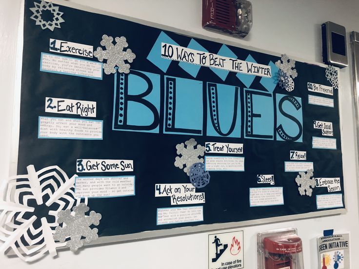 a bulletin board that has been decorated with blue and white snowflakes on it