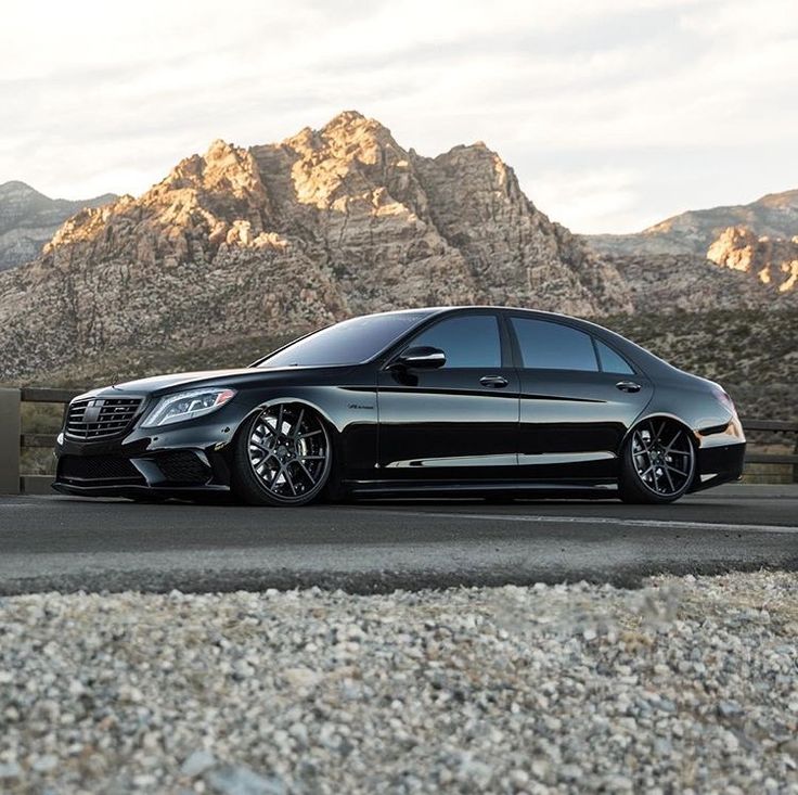 a black car parked in front of mountains