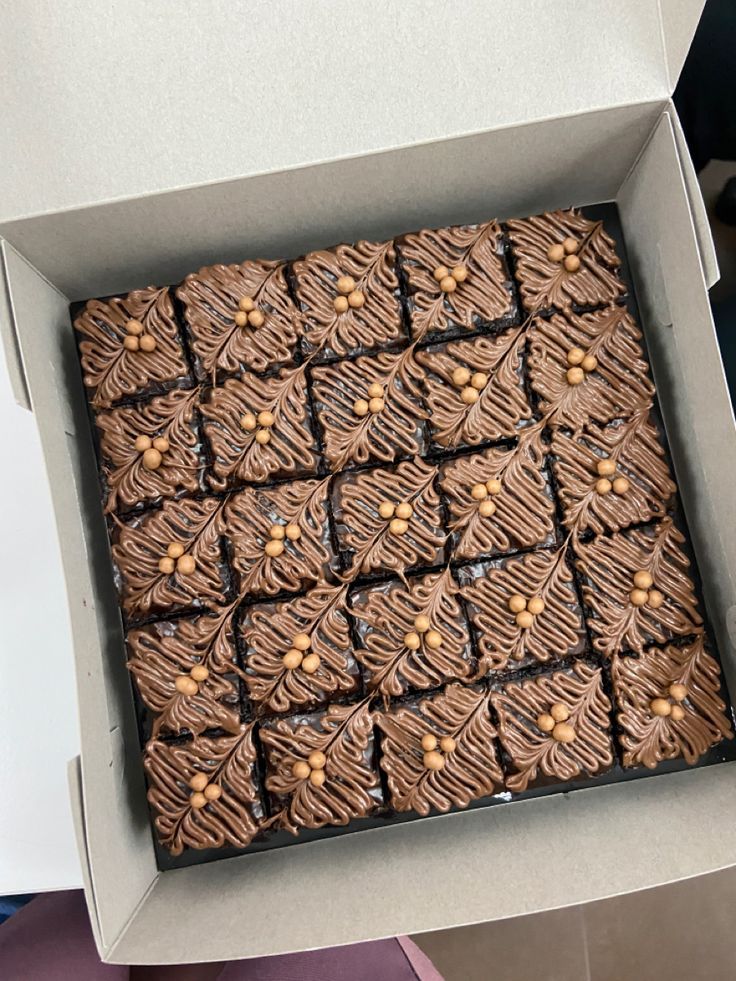 a box filled with brownies covered in nuts