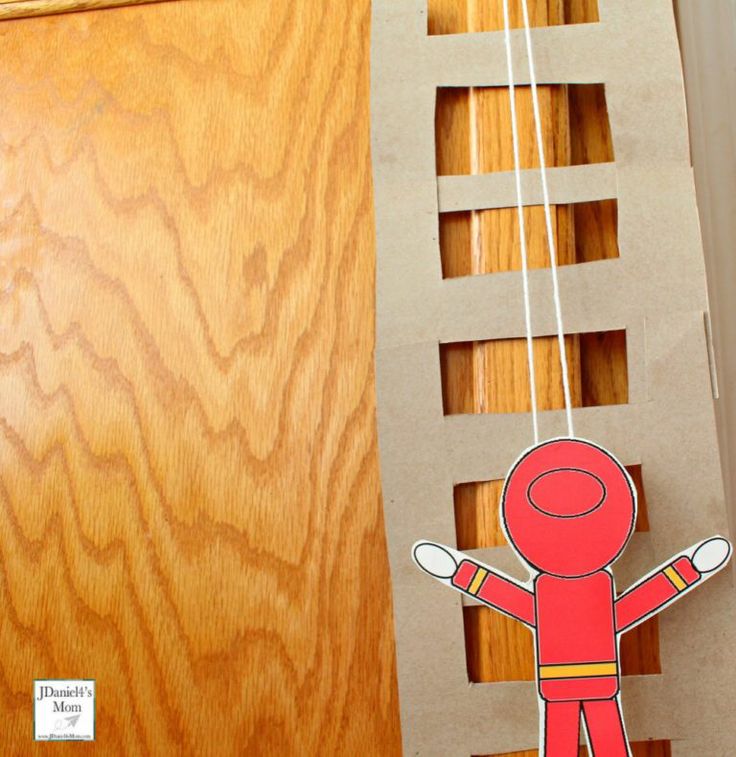 a paper cut out of a person hanging from a string on top of a wooden door