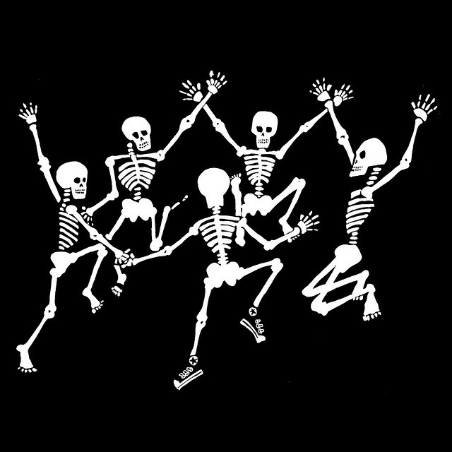 three skeleton dancing in the dark with their arms up