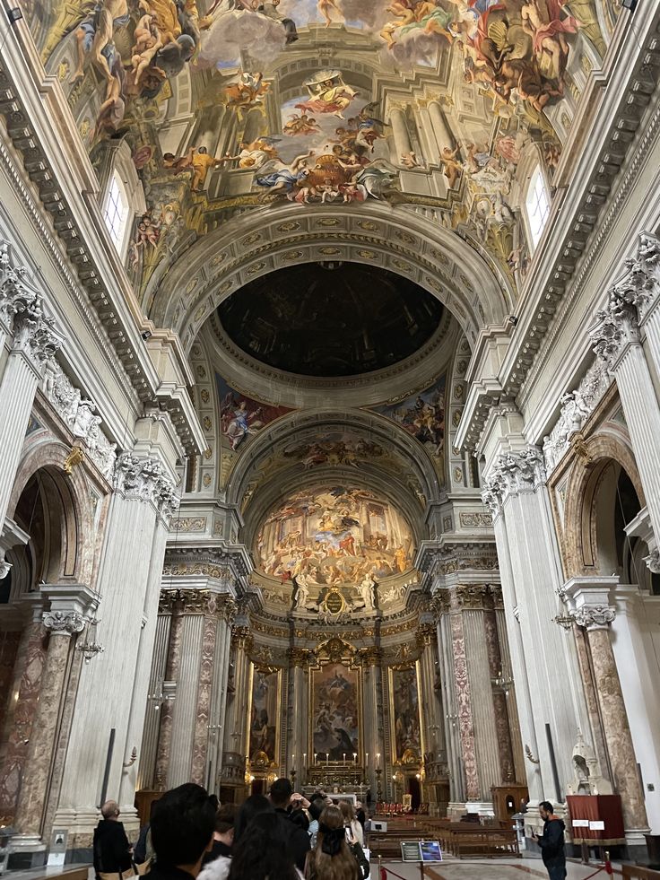 the interior of a church with people standing in front of it and paintings on the ceiling