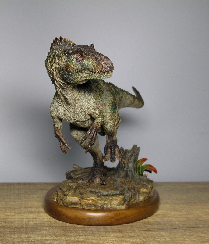 a toy t - rex standing on top of a tree stump