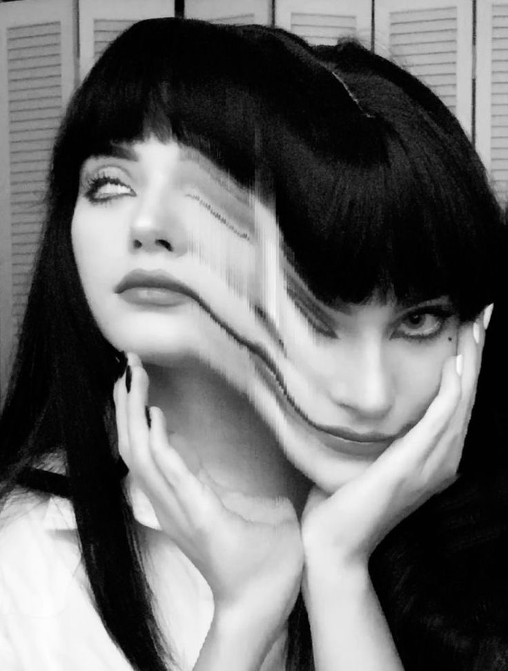 black and white photograph of a woman with long hair holding her hands to her face