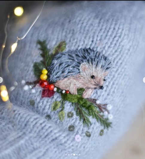 a close up of a sweater with a hedge on it and lights in the background