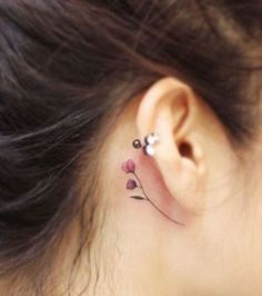 a woman's behind the ear tattoo with pink flowers on her left right ear