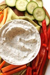 a plate with carrots, cucumbers and dip