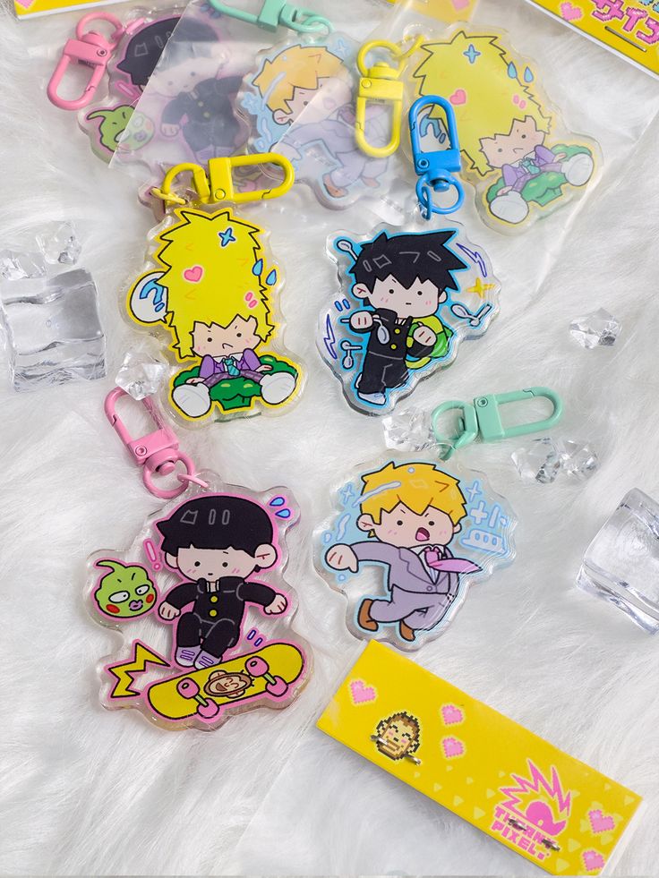 various cartoon keychains are laying on a white furnishce with tags attached to them