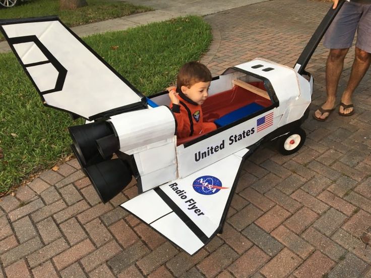 a young boy sitting in an airplane shaped toy