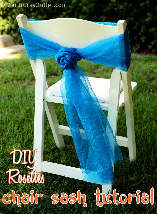 a chair with a blue sash tied to it's back sitting in the grass