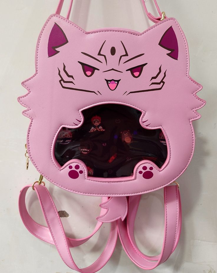 An itabag featuring everyone's favorite curse cat! This ita bag is made with pu leather as well as cotton insides for a sturdy exterior and a soft interior.  It comes with one main storage compartment as well as 4 internal pockets: one large padded pocket, two smaller open pockets, and one zipper pocket. Itabag Size: 9" x 9" x 3" (14" total with tail and ears) The ita bag includes:  - 1 Removable tail  - 1 Crossbody strap - 2 Backpack style straps - 1 Removable purple insert For extra inserts or Gojocat bag, please check out my other shop listings! Kawaii Style Large Capacity Standard Backpack, Kawaii Large Capacity Standard Backpack, Kawaii Shoulder Bag With Cat Design For Daily Use, Kawaii Cat Design Shoulder Bag For Daily Use, School Shoulder Bag With Cat Design, Kawaii Crossbody Bag With Removable Pouch, Harajuku School Bag With Cat Design, Pink Rectangular Backpack With Cat Design, Cute Cat Design Satchel Bag