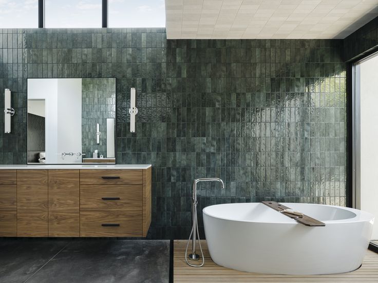 a large bathtub sitting in the middle of a bathroom next to a wooden vanity