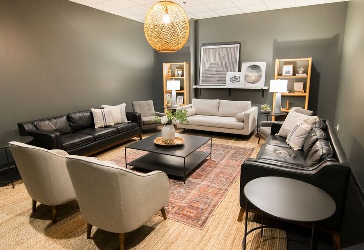 a living room with couches, chairs and a rug on the floor in front of it