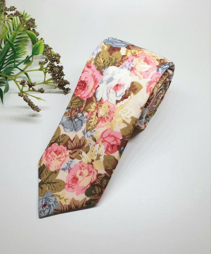 "The Blooming Roses floral tie  is a skinny tie which features  clusters of traditional Roses in a mixture of gorgeous colours blue, pinks, reds and greens. It is the perfect tie for weddings, formal occasions, proms, graduations or simply for work.  Made  from 100% Cotton Tie Measurements Width - 6 cm or 2.36\" Length - 145cm or 57\" The Blooming Roses floral tie matches with the Dusty Blue Ties & Bow Ties available here -  https://www.etsy.com/listing/1495742138/dusty-blue-tie-groomsmen-tie-bluetie CARE INSTRUCTIONS Dry Clean only Spot Clean Warm Iron Please note if you require more than the displayed amount in stock please message me with the date you require the items as I may have more available for purchase. Great gift for your husband to be, father, groomsmen, Son, boyfriend or uncl Wedding Suit Accessories With Floral Print Standard Tie, Multicolor Floral Print Wedding Ties, Multicolor Fitted Suit And Tie Accessories For Wedding, Floral Print Tie For Groom, Floral Print Ties For Groom, Floral Print Ties For The Groom, Floral Print Standard Tie For Groom, Groomsmen Tie, Tie Matching