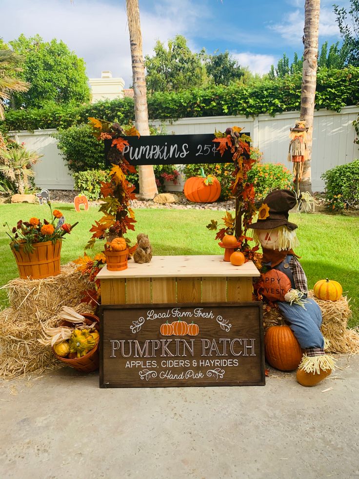 a pumpkin patch sign sitting on top of a wooden bench next to hay bales