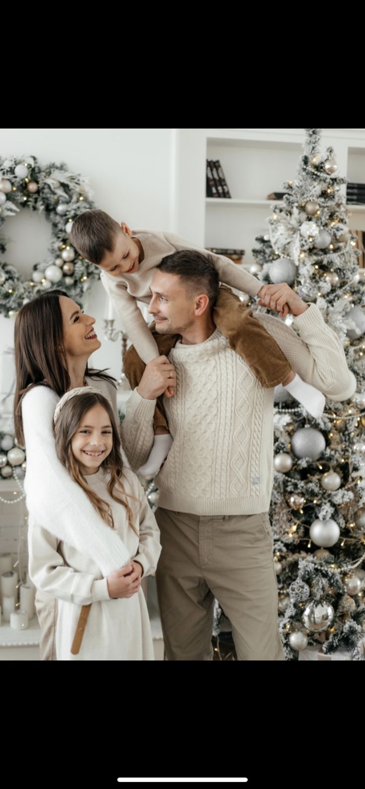 a family is posing in front of a christmas tree