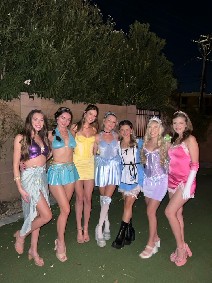 a group of young women standing next to each other wearing costumes and posing for the camera