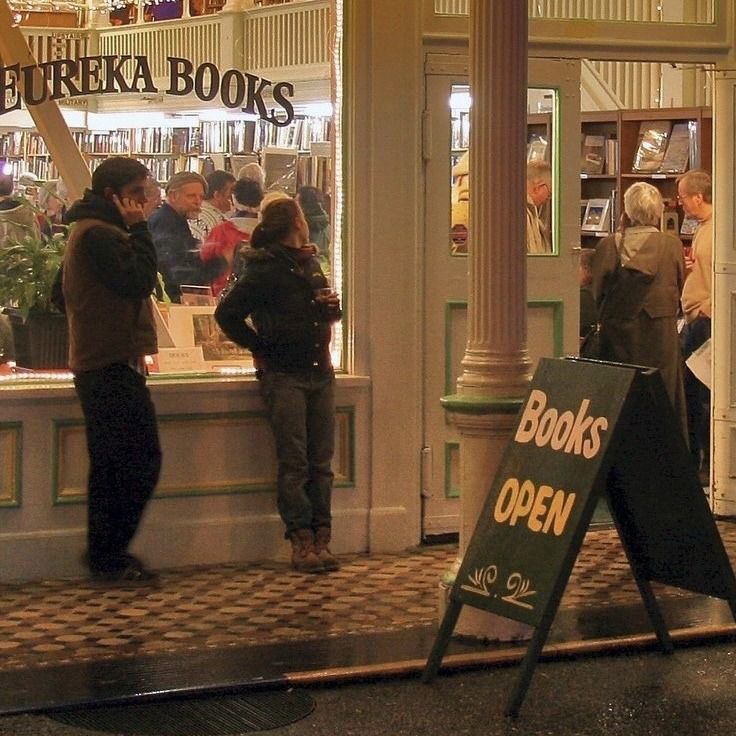 people are standing in front of a book store