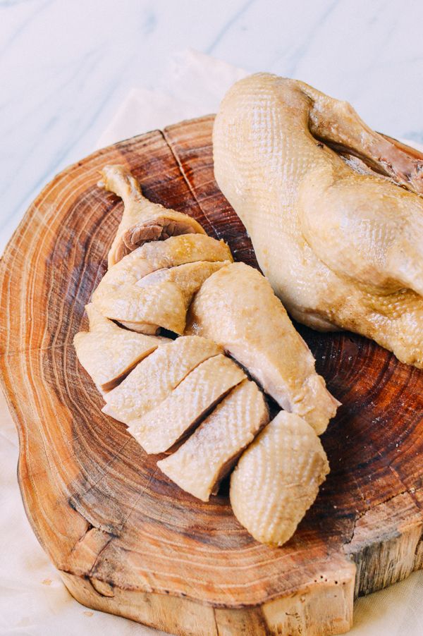 two pieces of chicken sitting on top of a wooden plate