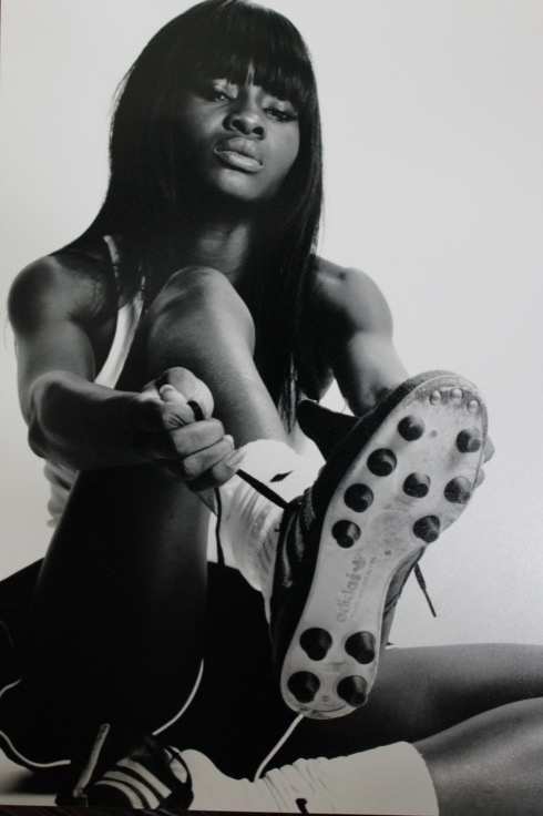 a black and white photo of a woman holding a tennis racquet